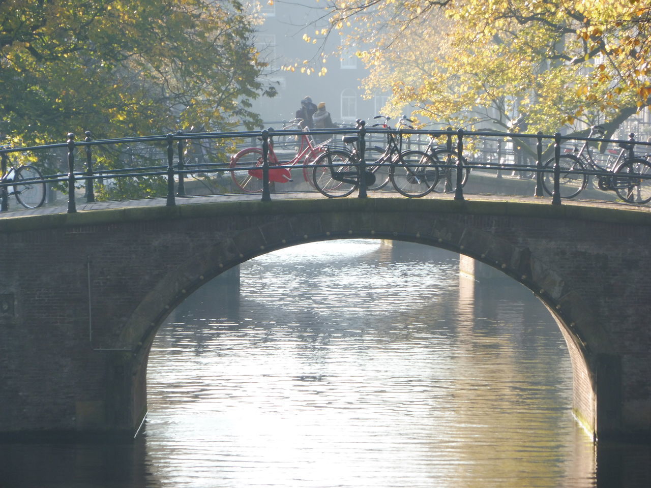 ARCH BRIDGE OVER RIVER DURING SUNSET