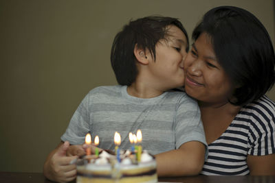 Close-up of son kissing mother during birthday