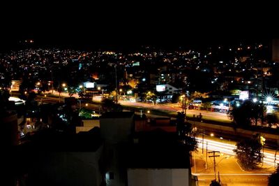 Illuminated cityscape against sky at night