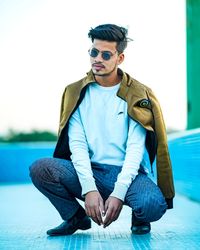 Young men wearing sunglasses while sitting on snow