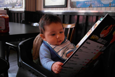 Close-up of cute baby girl sitting in kitchen