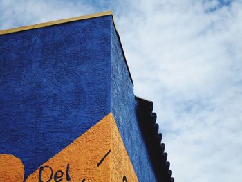 Low angle view of arrow symbol against blue sky