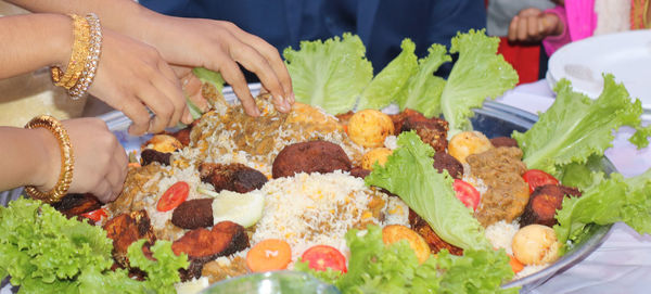 Close-up of hand with vegetables on table