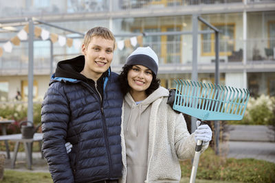 Young people holding garden tools