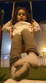 Low angle view of girl on swing
