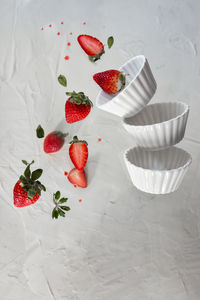 Red strawberries levitating on a white background. levitation effect.