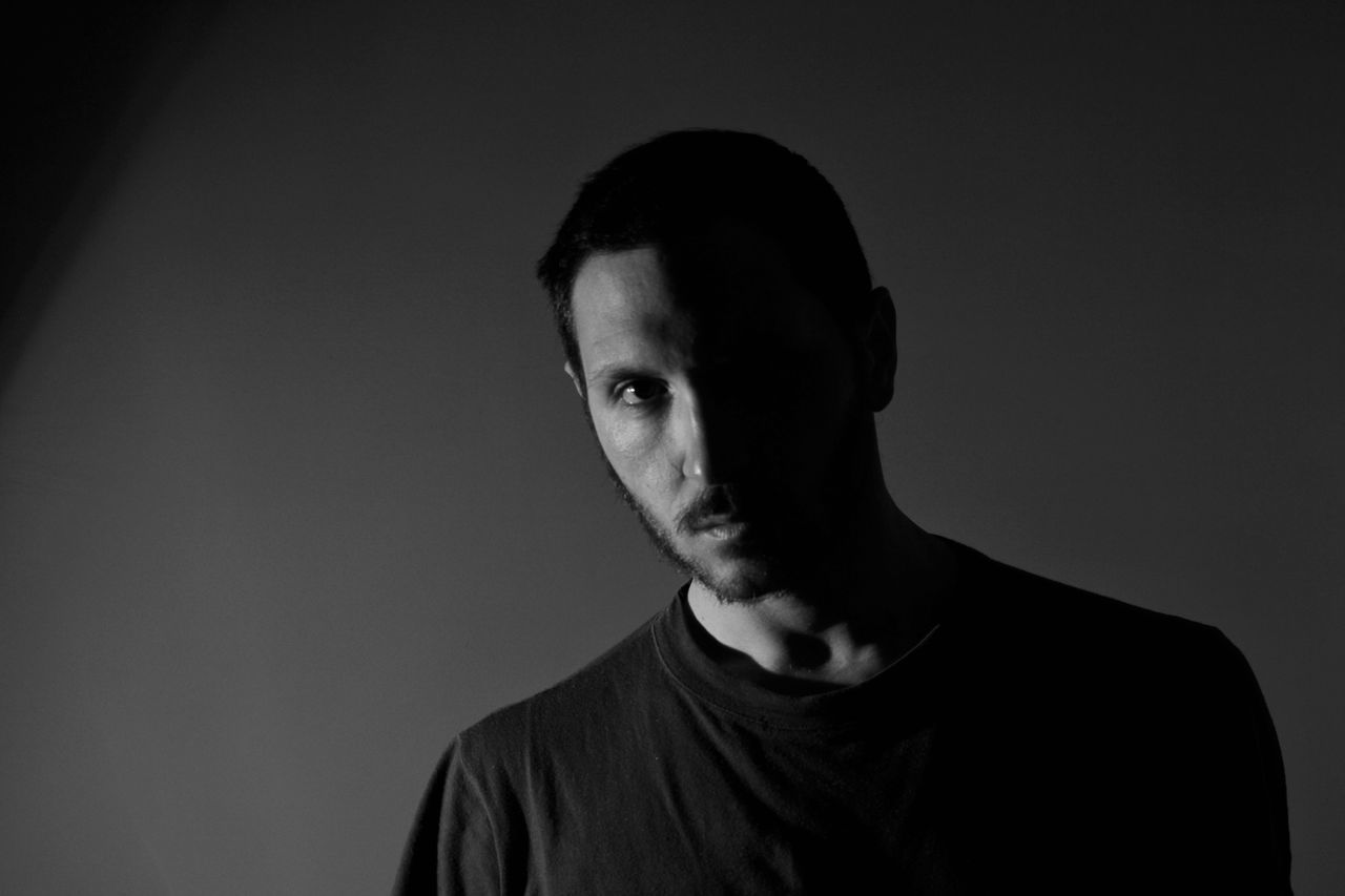 portrait, one person, headshot, studio shot, young men, indoors, front view, looking at camera, young adult, casual clothing, copy space, men, serious, lifestyles, wall - building feature, confidence, gray background, handsome, black background, contemplation, human face