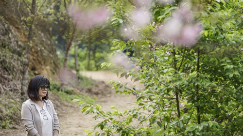 Portrait of woman standing by plants