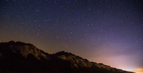 Low angle view of mountain against star field sky at night