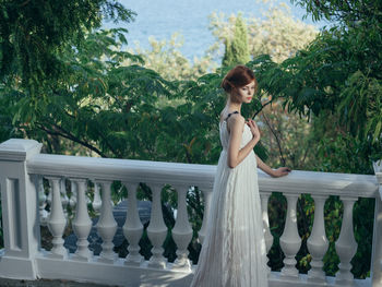 Side view of woman standing on balcony