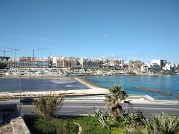 High angle view of buildings by sea against clear sky