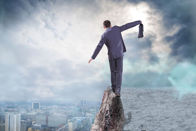 Digital composite image of man walking on cliff against cityscape