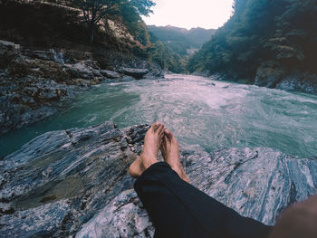 Low section of person on rock in water