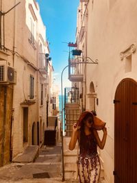 Woman walking on footpath by buildings