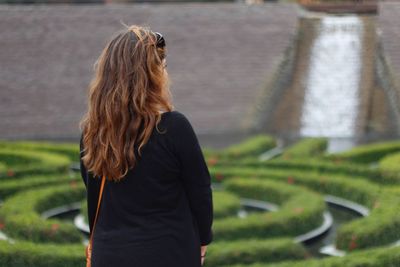 Rear view of young woman standing at park