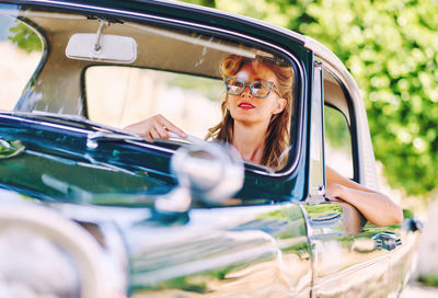 Smiling woman driving vintage car