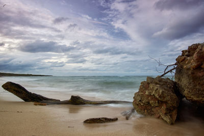 Rocks on beach against sky