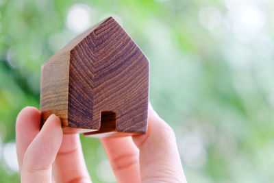 Cropped hand holding wooden model home