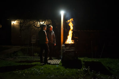 A father and son build a barbecue fire on their plot to cook dinner on an open fire