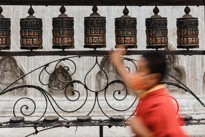 Side view of woman standing against wall