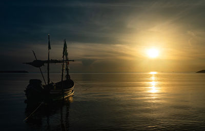 Sailboats in sea against sky during sunset