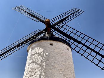 Low angle view of traditional windmill against clear blue sky