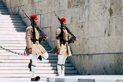 People standing on staircase against building