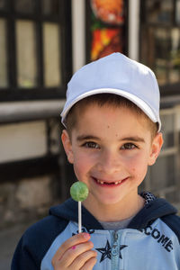 Portrait of smiling boy holding lollipop outdoors