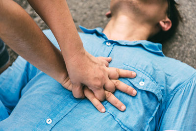 Midsection of man with hands sitting outdoors