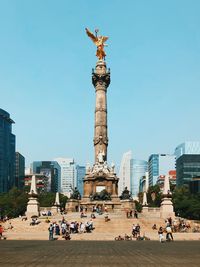 Statue in city against clear sky