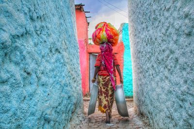 Low section of woman standing against multi colored wall