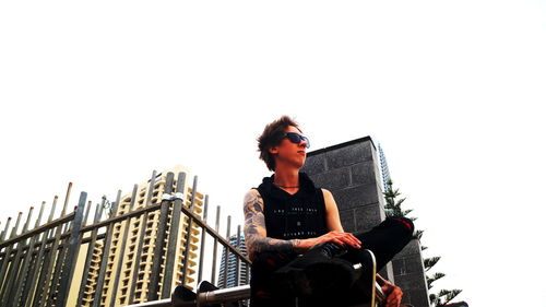 Young handsome tattoed guy looking into the horizon and contemplating the future in the city