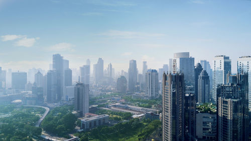 Aerial view of buildings in city against sky