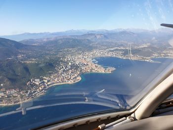 Aerial view of cityscape against sky seen through airplane window