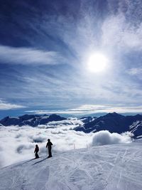 People skiing on snowcapped mountain against sky