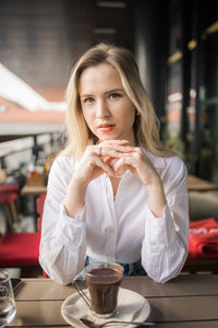 Portrait of young woman drinking glass