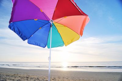 Close-up of umbrella on beach against sky