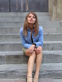 Beautiful young woman sitting on staircase