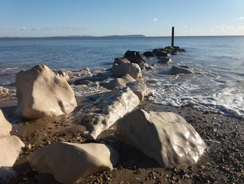 Rocks on beach against sky