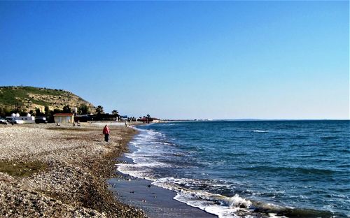 Scenic view of beach against clear blue sky