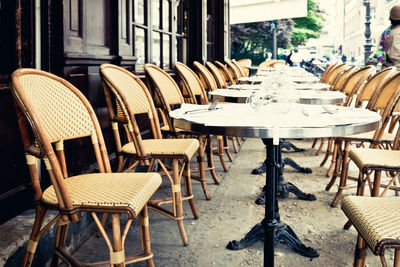 Empty tables and chairs at sidewalk cafe