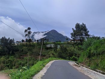 Road amidst plants and mountains against sky