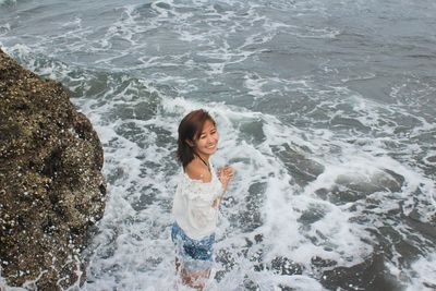 High angle view of young woman standing in sea