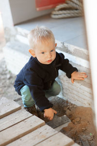 Cute baby boy looking away while crouching