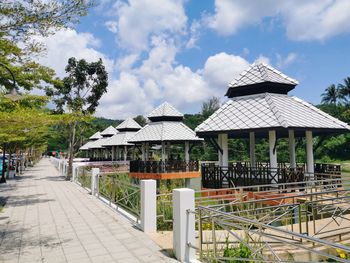 Built structure on footpath by building against sky