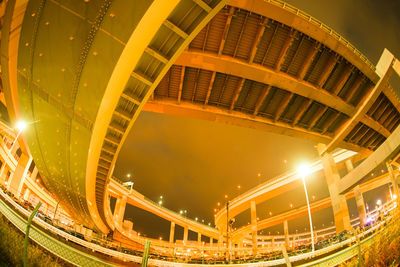 Low angle view of illuminated bridge against sky at night