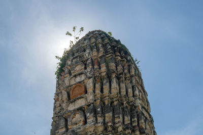 Low angle view of cross on rock against sky