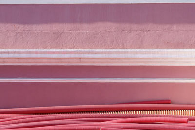 Red plastic pipes by wall