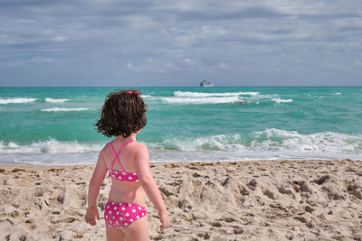 Cute young girl playing and fooling around at the beach