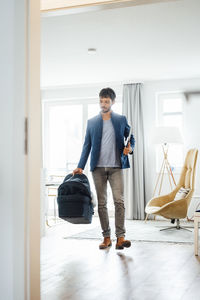 Full length portrait of young man standing at entrance